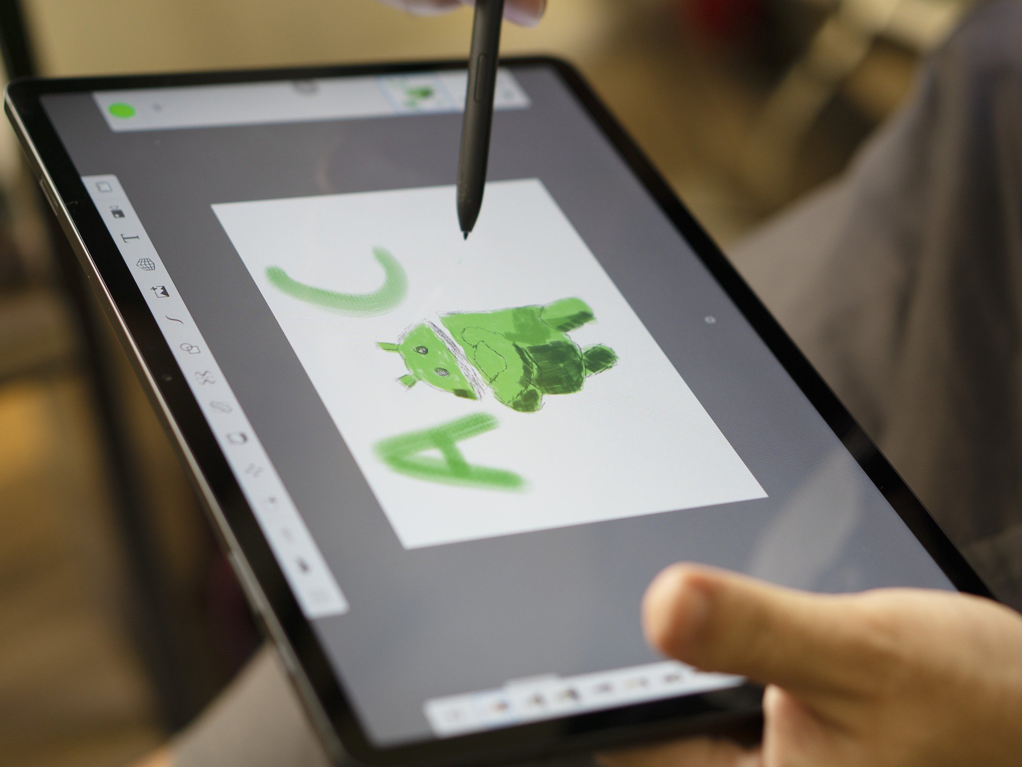 Photo of the Samsung Galaxy Tab S7 FE. Someone draws an Android figurine using the S Pen.