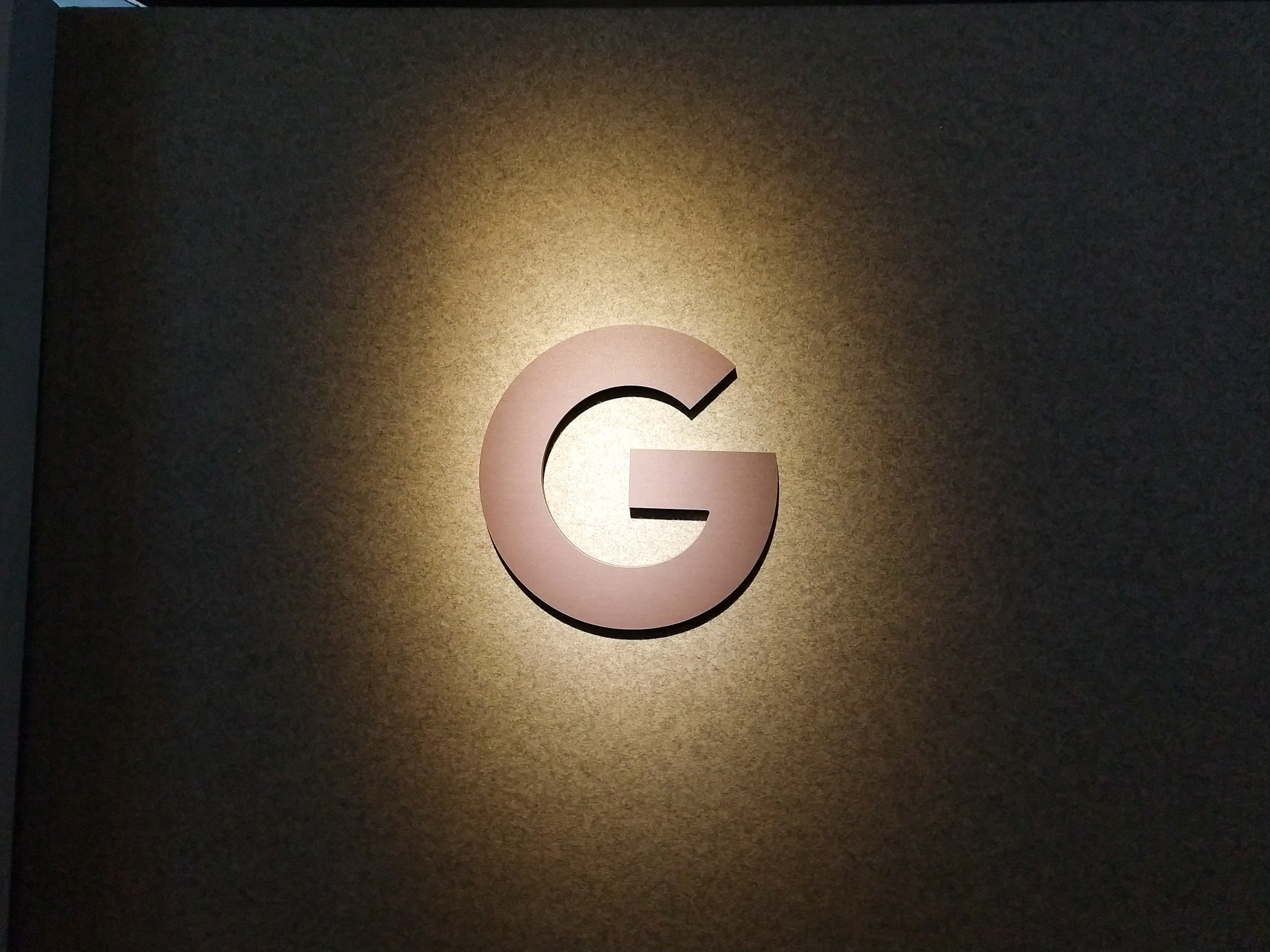 The Google logo in black and white under a sepia shadow