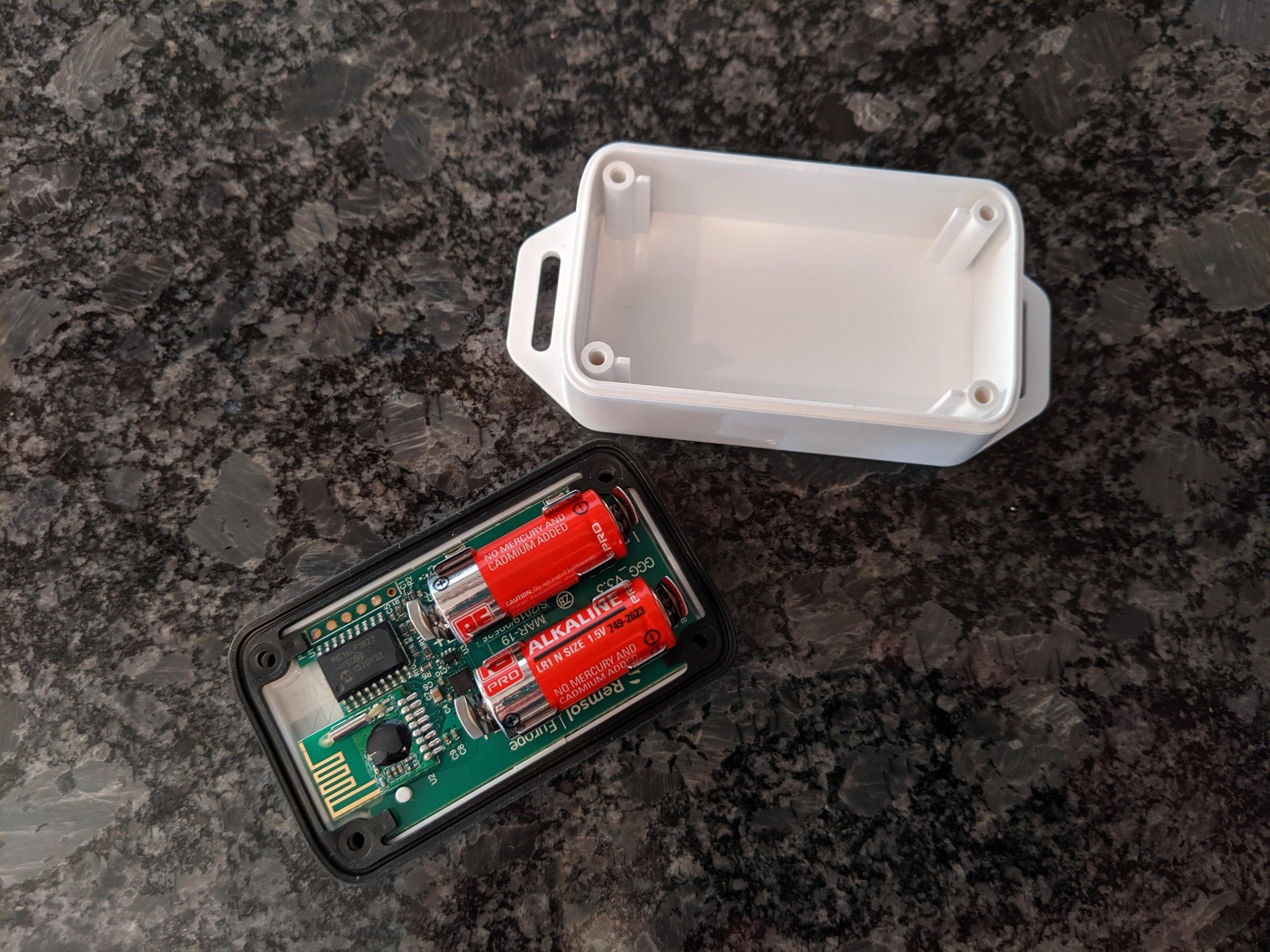 The iSmartGate Pro sensor taken apart with batteries exposed.