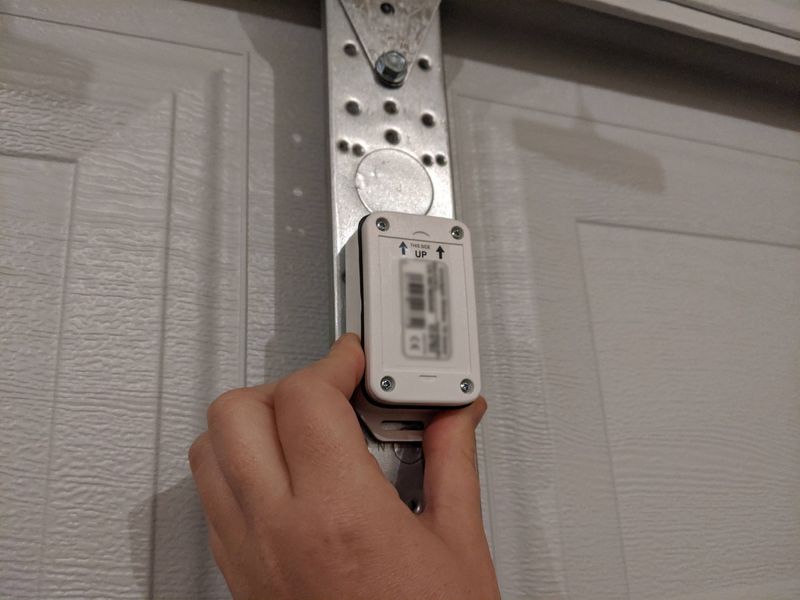 The iSmartGate Pro being attached to garage door with adhesive